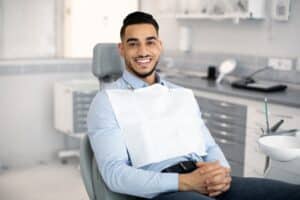 A man smiling in a dentist's chair after teeth whitening in Spokane