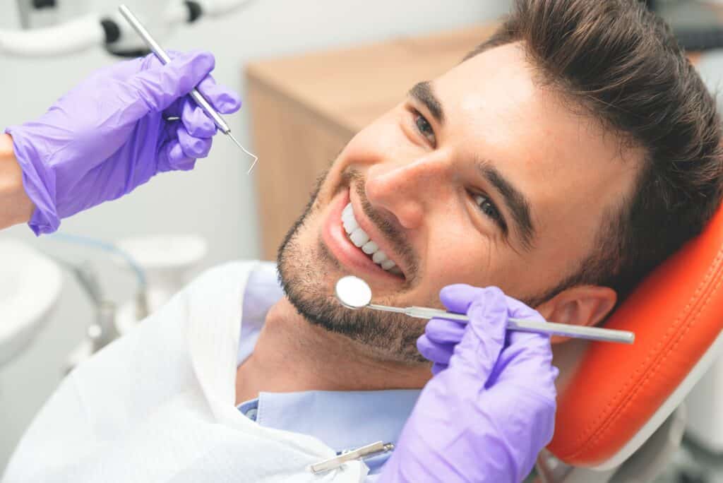 A man smiling while undergoing general dentistry care